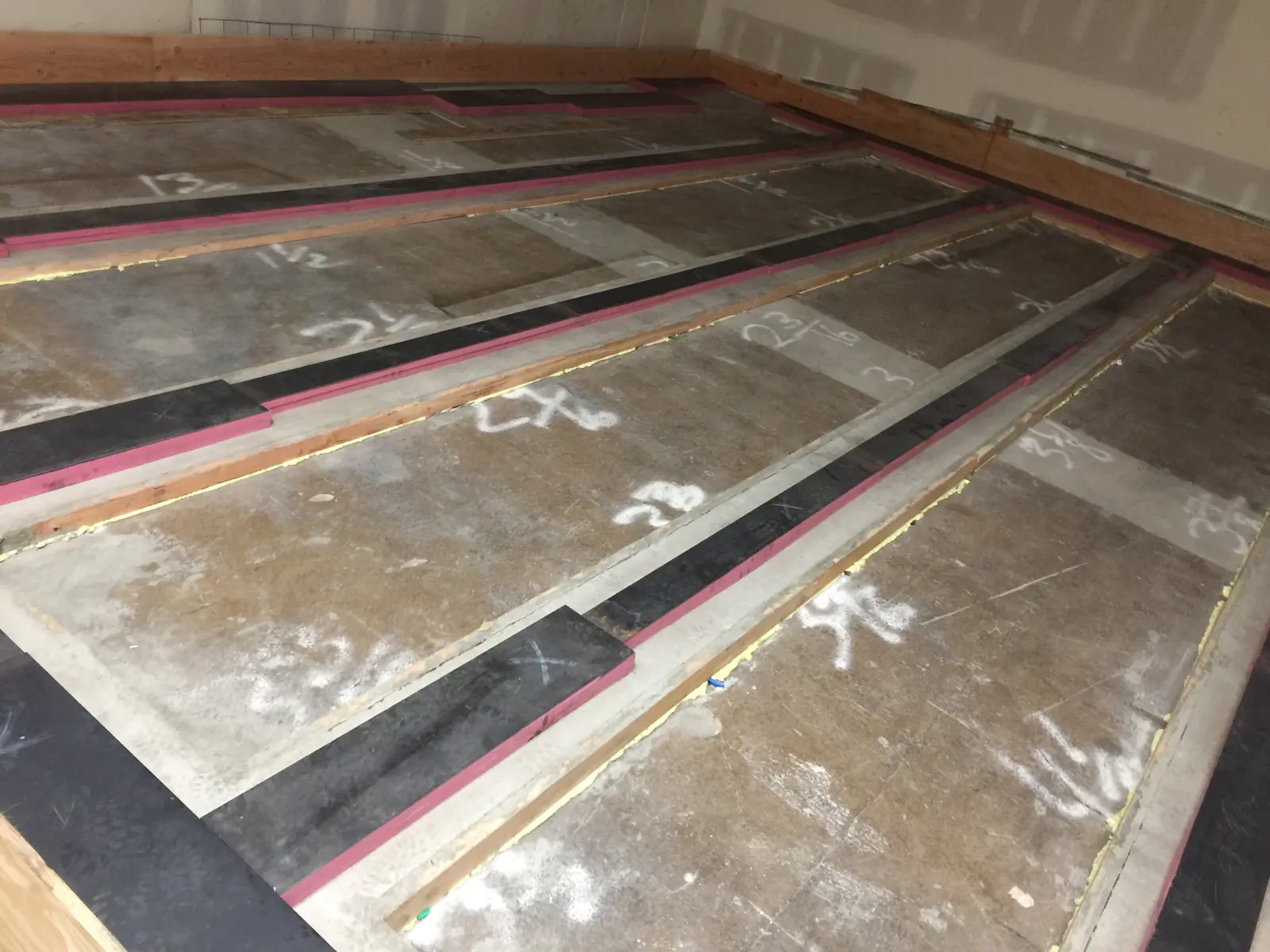 Concrete floor poured on steel pan forms which are mechanically detached from building with steel shims on pink sylomer foam resting on concrete curbs. This helps reduce outside vibrations.